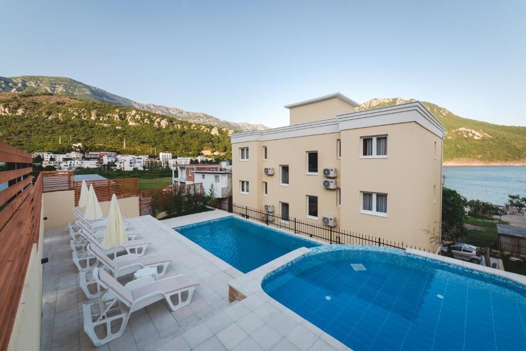 Swimming pools and sun loungers overlooking the sea at Villas Promis in Čanj