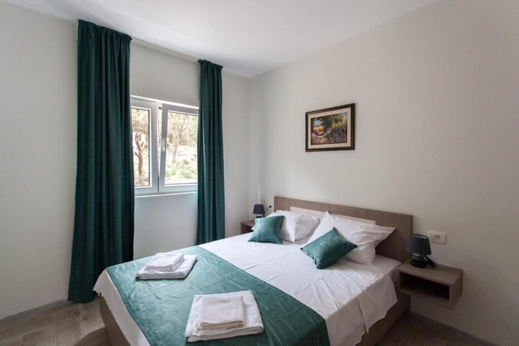 Bedroom with queen bed and green details in a Villas Promis apartment